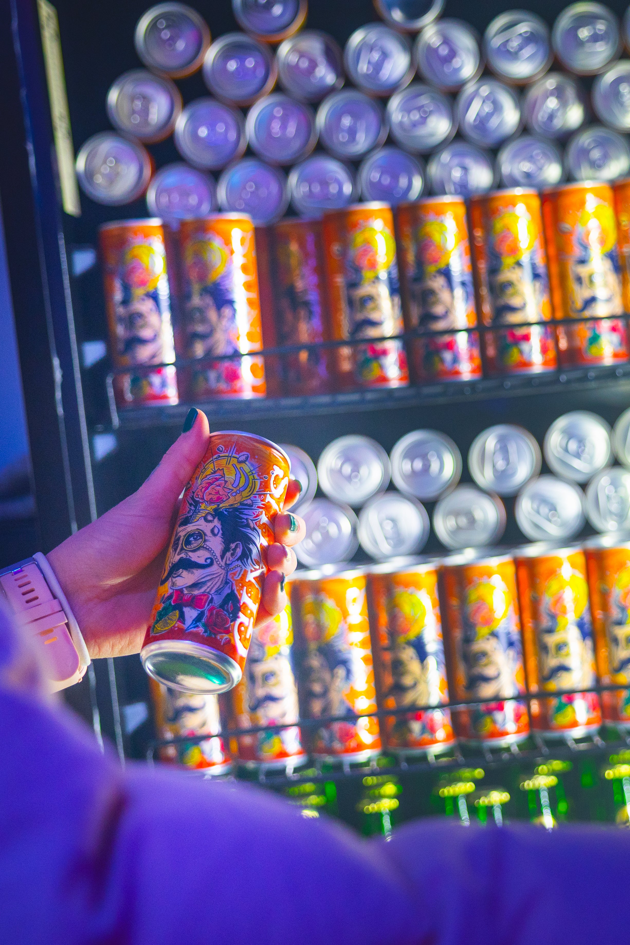 Vending machine filled with Gin&Tonic cans, with a hand holding a can in front.