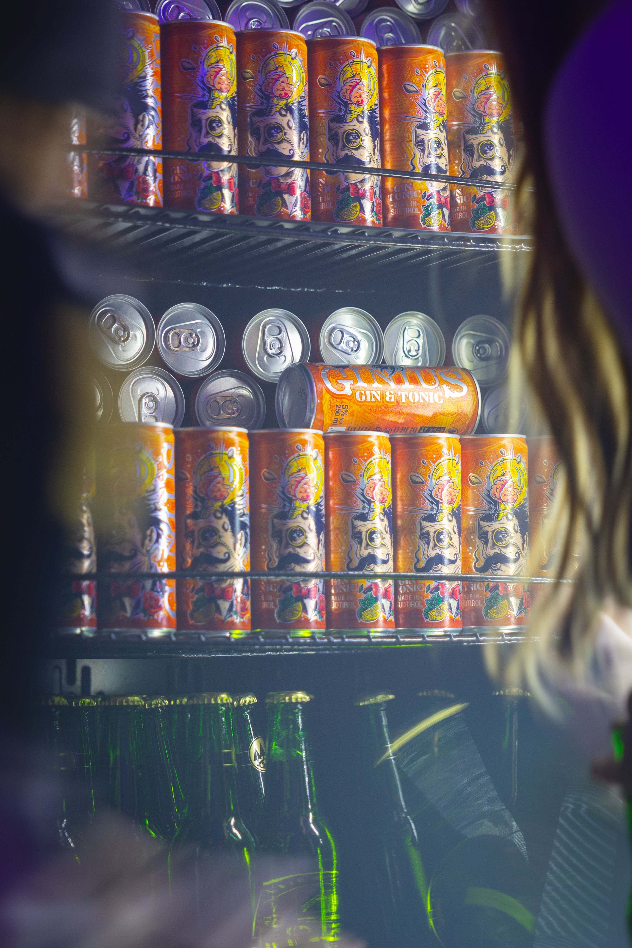 Fridge stocked with various Gin Tonic cans, including a prominent display of orange and silver cans.